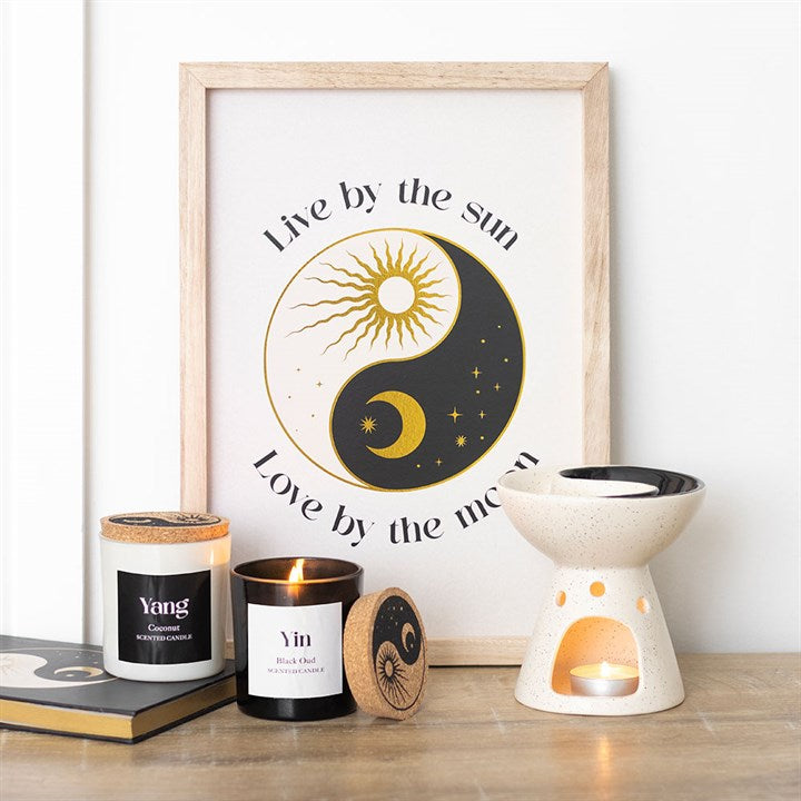 Set of 2 Yin Yang candles in black oud and coconut, elegantly displayed with a decor piece featuring sun and moon art.
