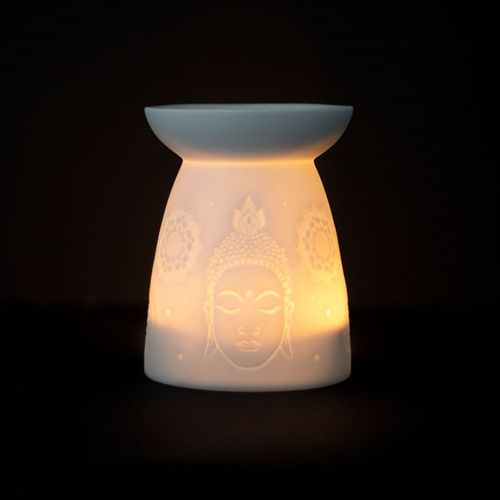 White ceramic Buddha face oil burner with a warm glow, perfect for aromatherapy and relaxation