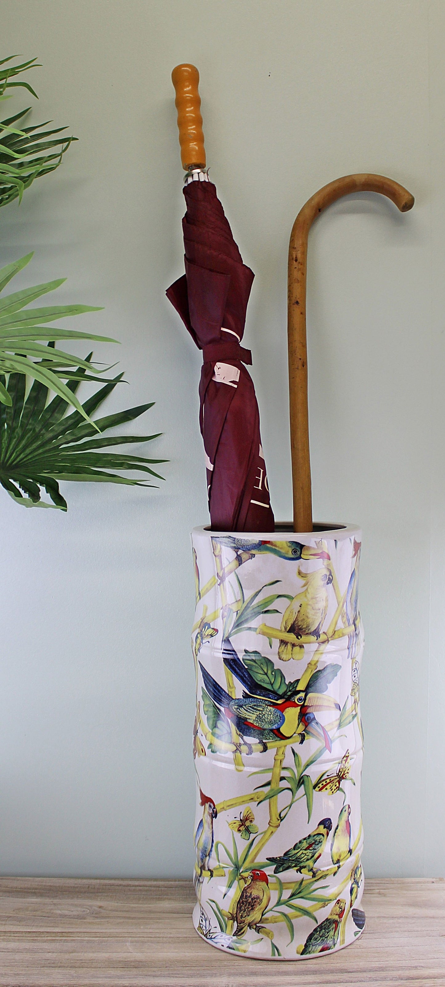 Geko Products ceramic umbrella stand tropical design holding a maroon umbrella and wooden cane