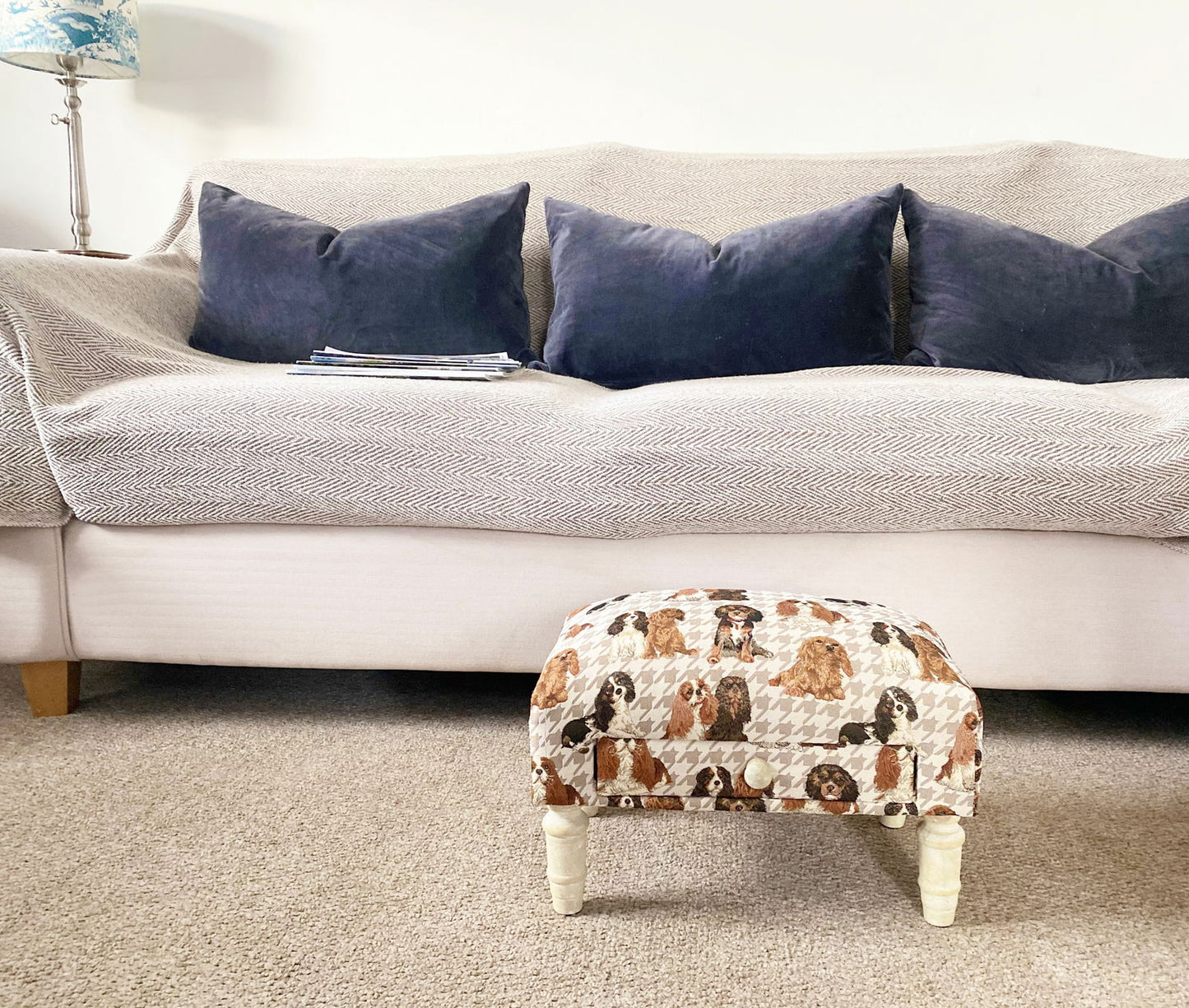 Decorative animal footstool with dog print upholstery and white wooden legs in a cozy living room