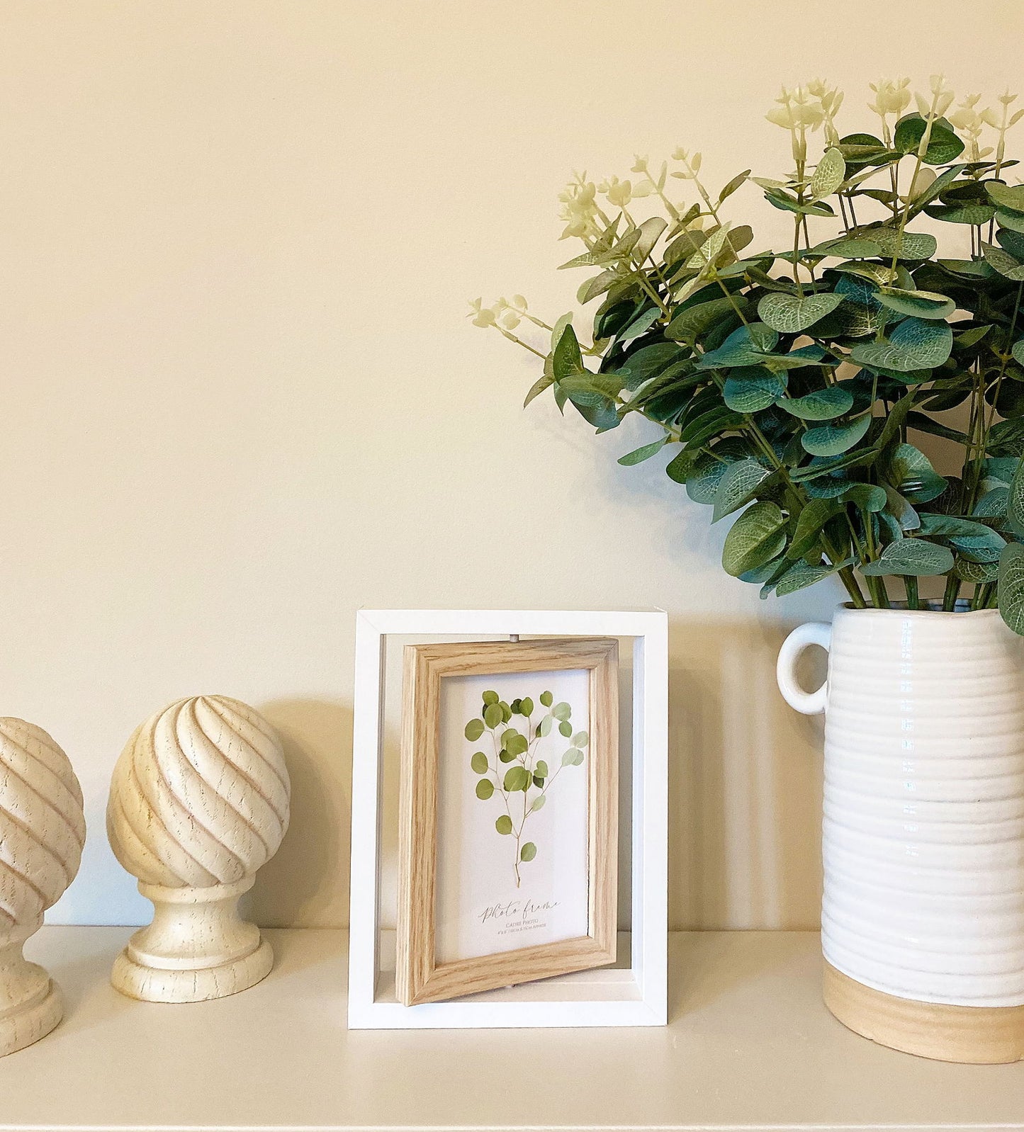 Geko Products white and wooden swivel photo frame displayed on shelf with decorative plants and ornaments