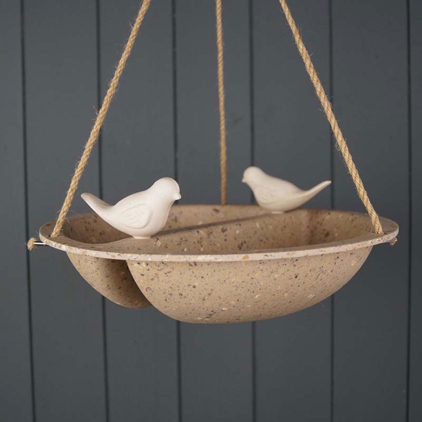 Earthy coffee husk bird bath feeder hanging with decorative white bird accents