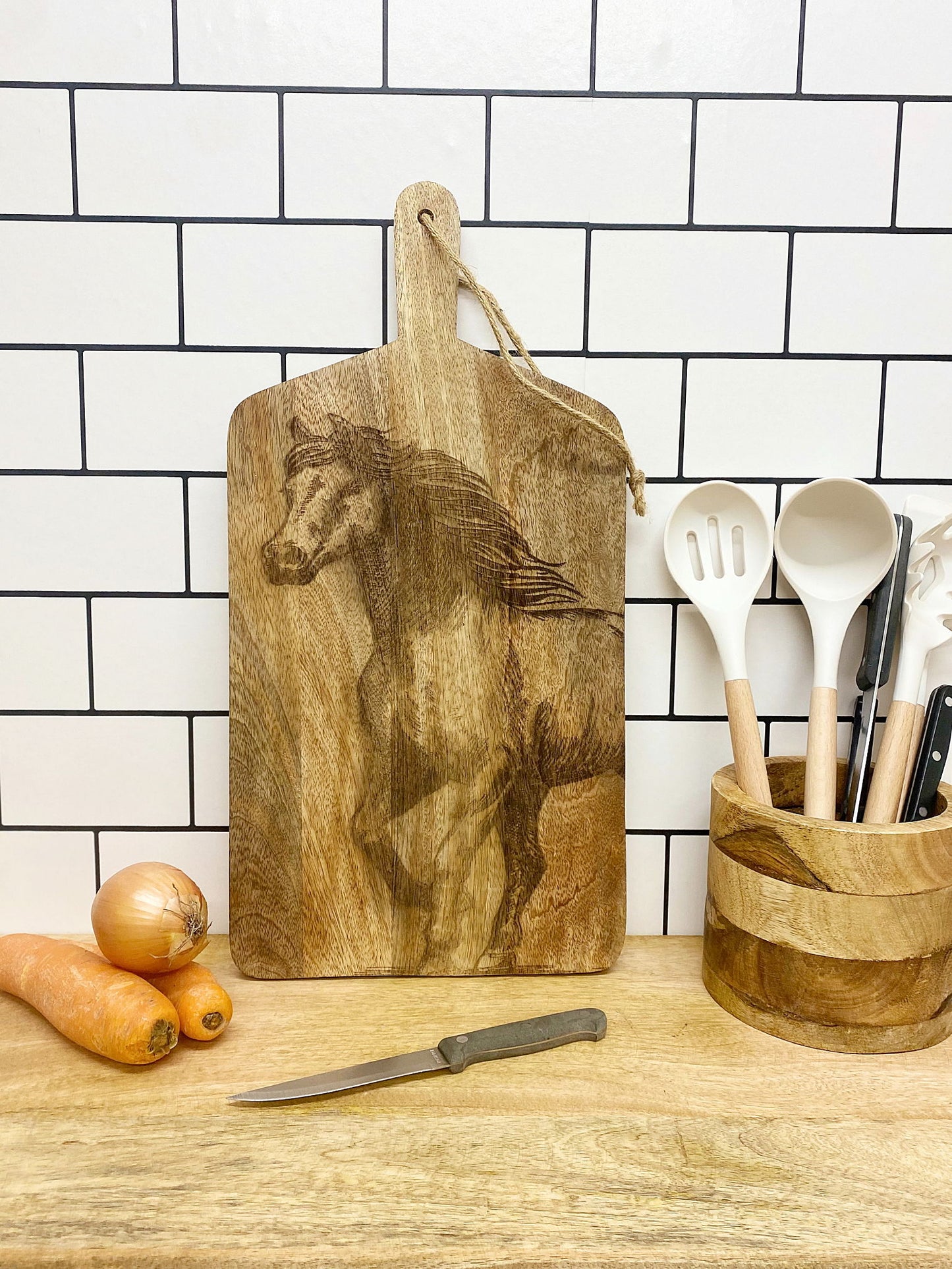 Engraved horse chopping board by Geko Products displayed on kitchen countertop with utensils and vegetables