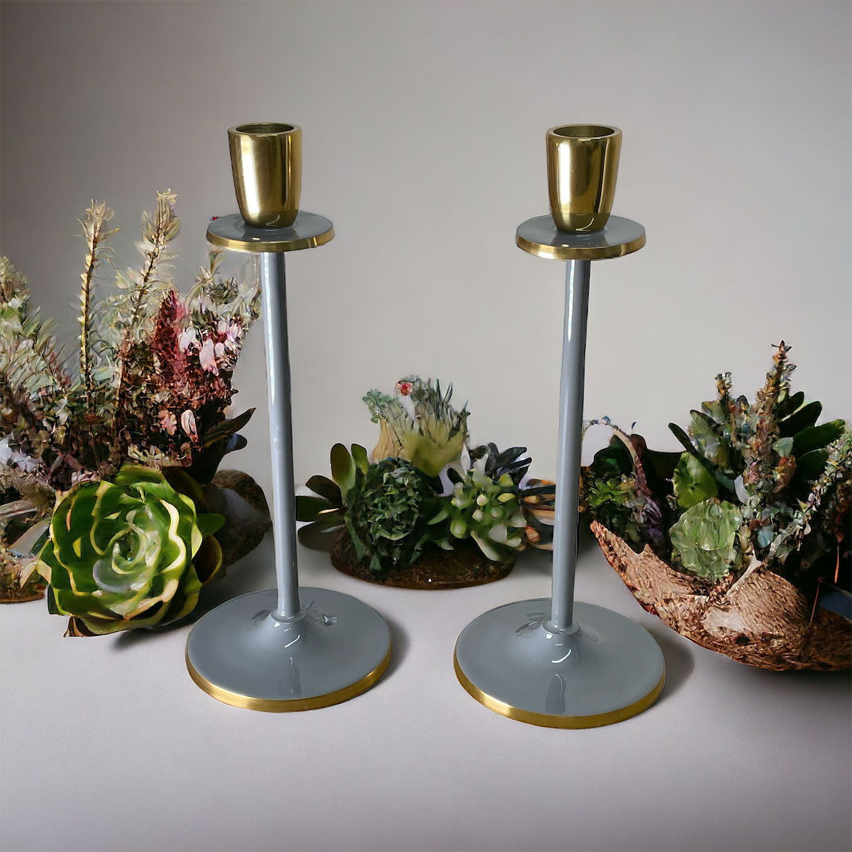 Glossy grey candlestick set with gold accents from Geko Products displayed with decorative succulents