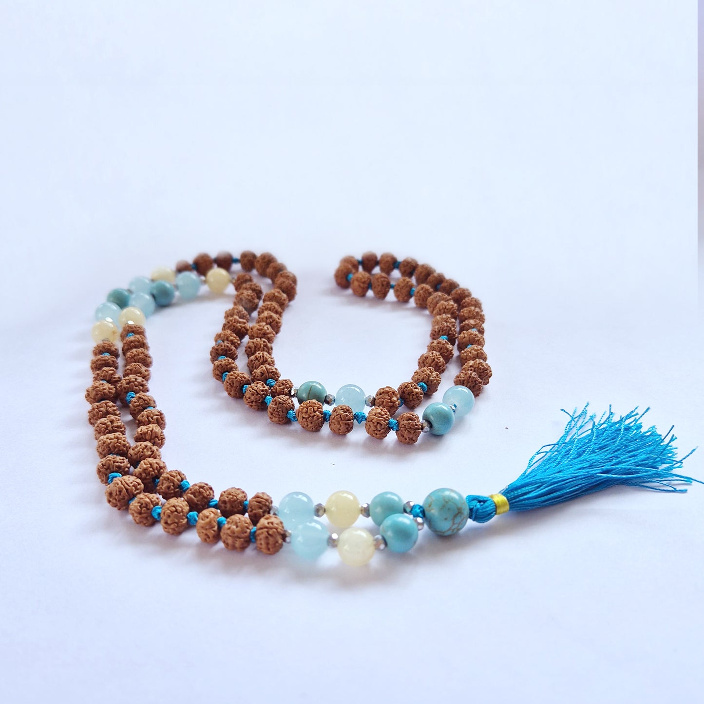 Mala necklace for fertility with natural beads and a blue tassel, designed for abundance and spiritual connection.