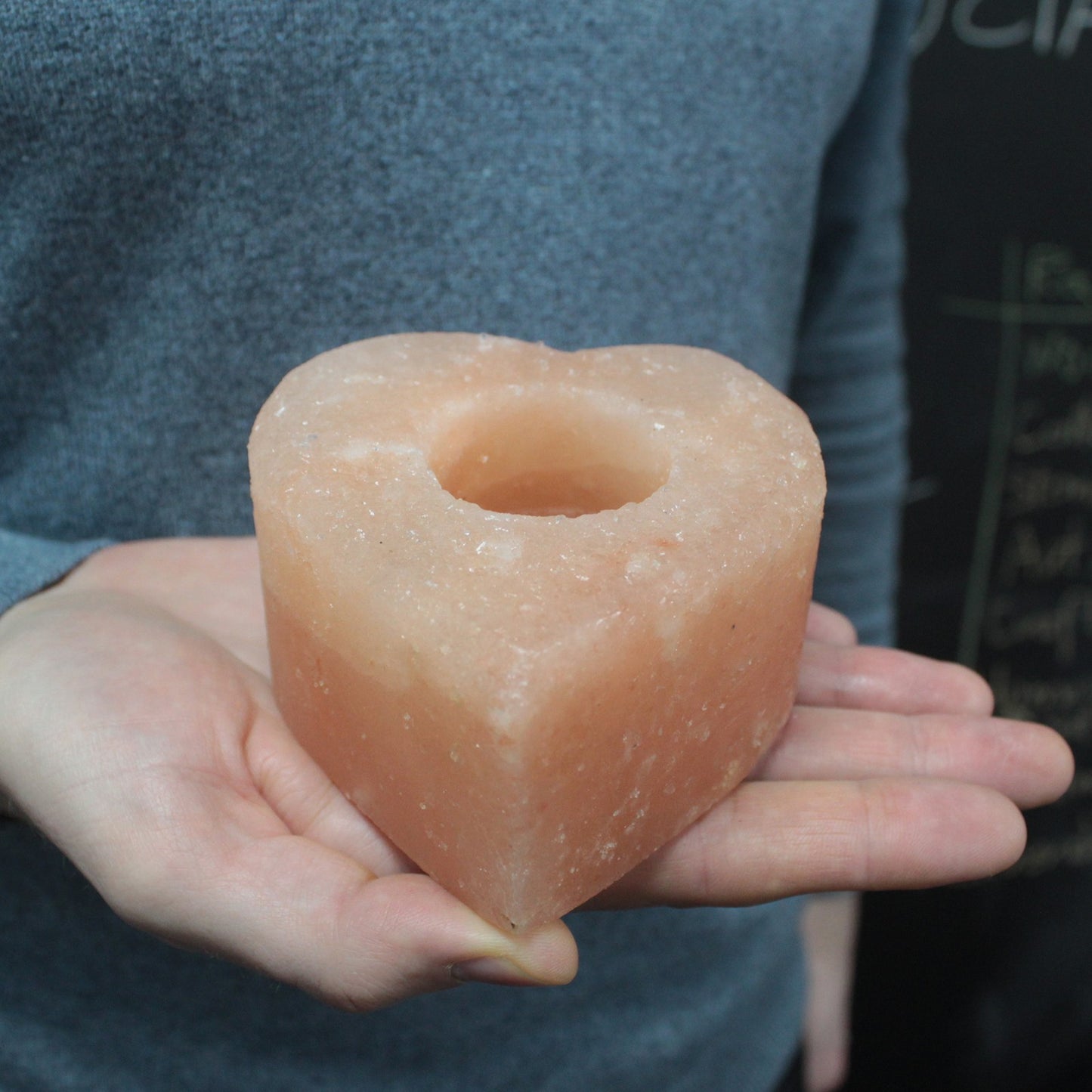 Medium heart shaped Himalayan salt candle holder shown in hand, perfect for cozy home decor