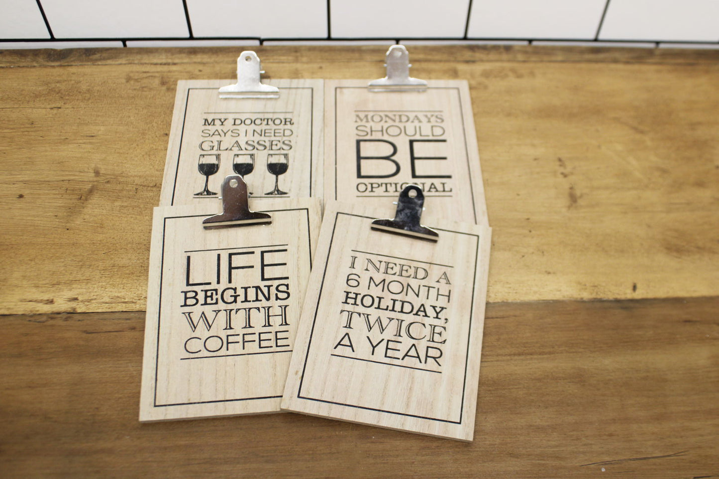 Motivational wooden clipboards with funny printed quotes on a wooden surface