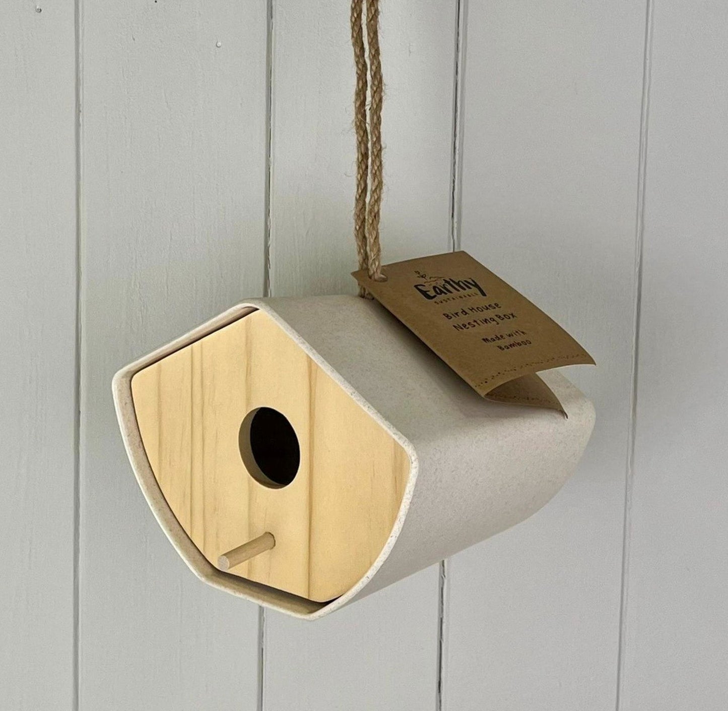 Natural bamboo Japandi birdhouse with beige exterior and wooden front panel hanging on twine