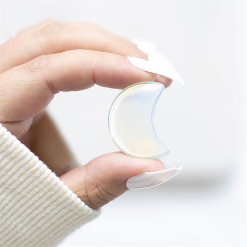 Stay Wild Opalite Crystal Moon held in hand, showcasing its iridescent glow and smooth texture