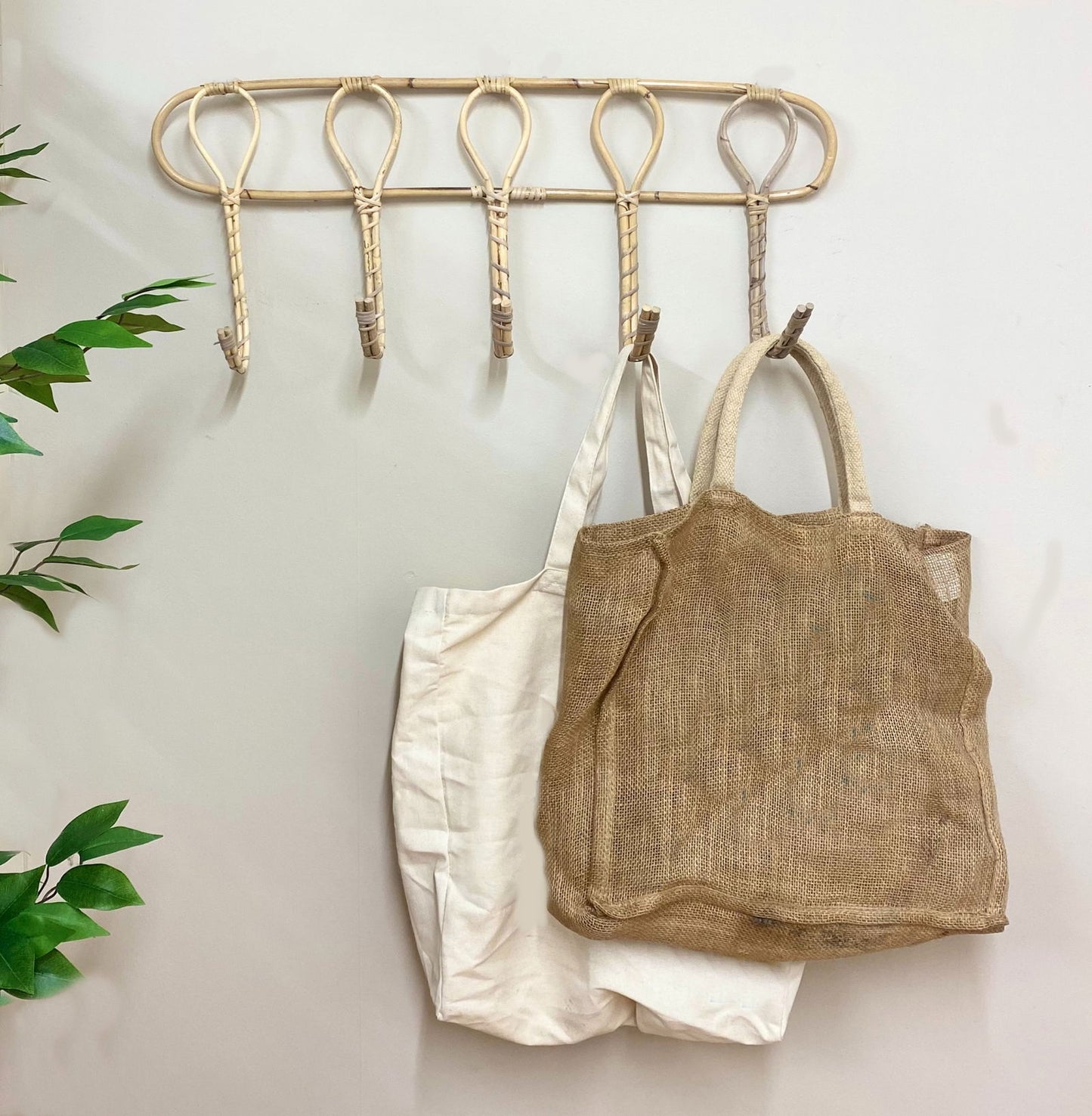 Geko Products rattan wall hooks mounted on a wall holding two fabric tote bags
