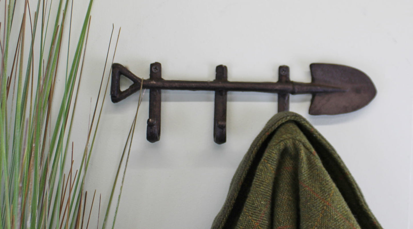 Rustic garden spade wall hooks by Geko Products mounted on wall holding a green coat
