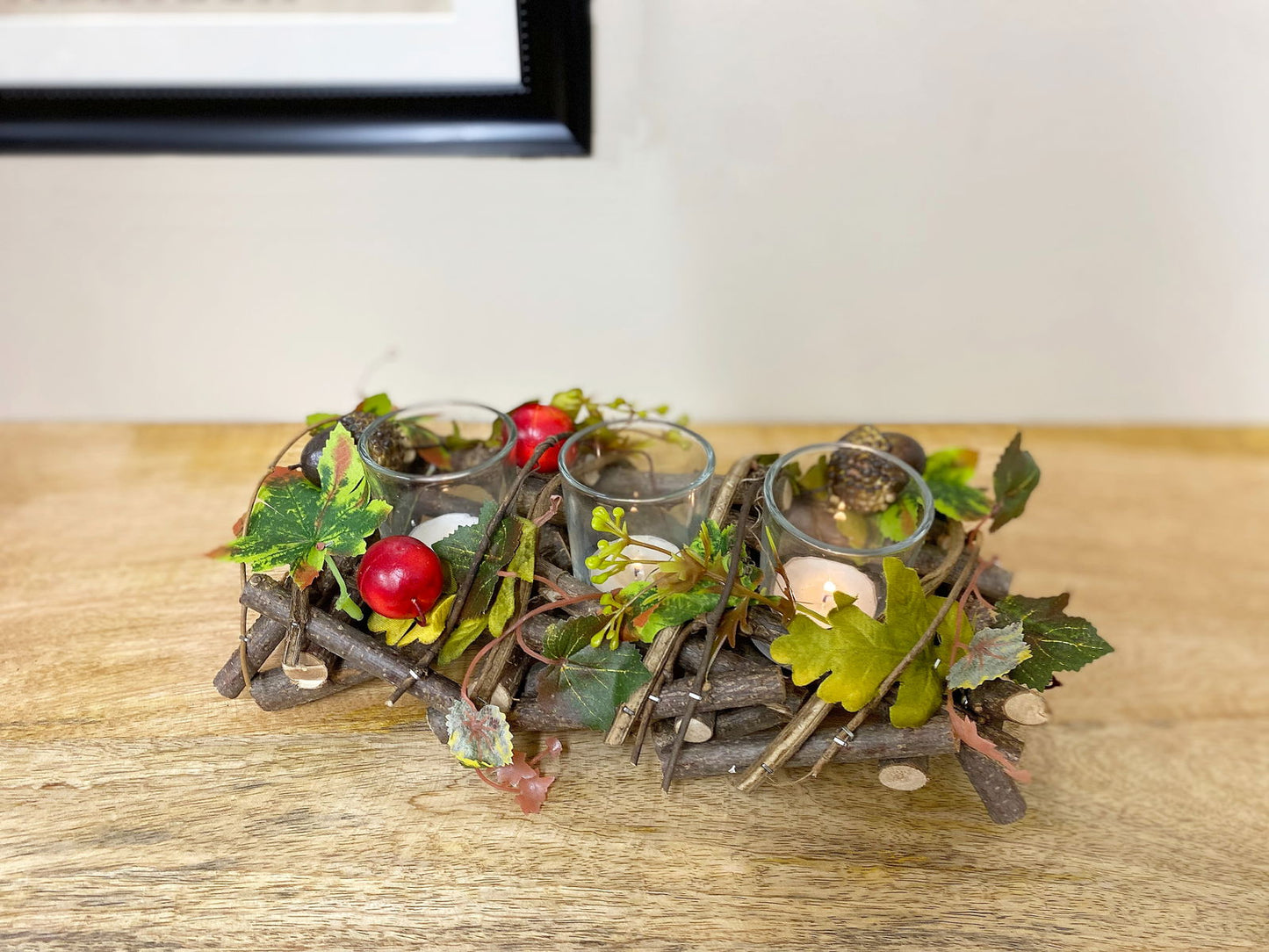 Geko Products triple tea light centerpiece with glass holders, artificial leaves, and red berries on wooden table