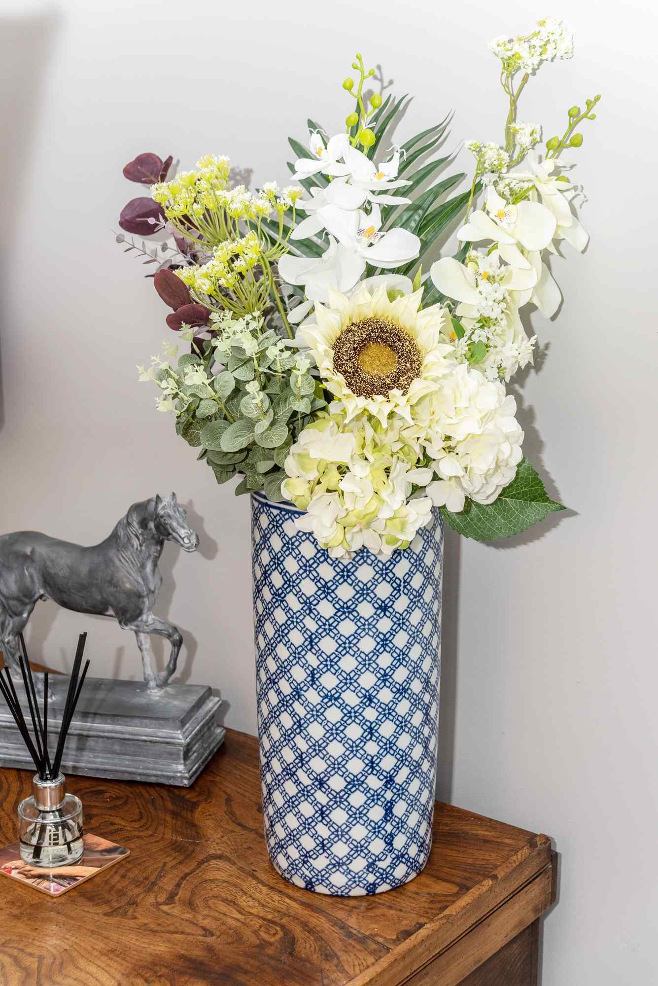 Geko Products floral umbrella stand with blue and white pattern holding artificial flowers on wooden table