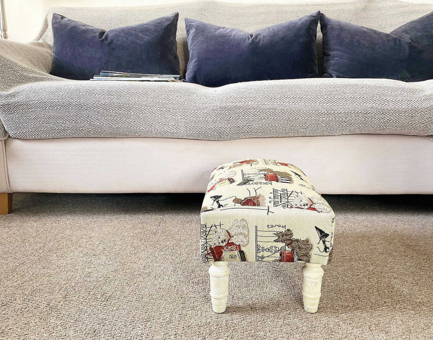 Scottie dog footstool with drawer featuring patterned fabric and white wooden legs in a living room