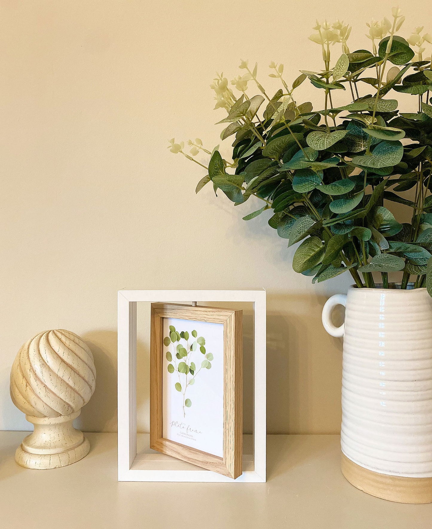 Geko Products swivel photo frame with wooden inner frame displayed on shelf with decorative plants and wooden decor