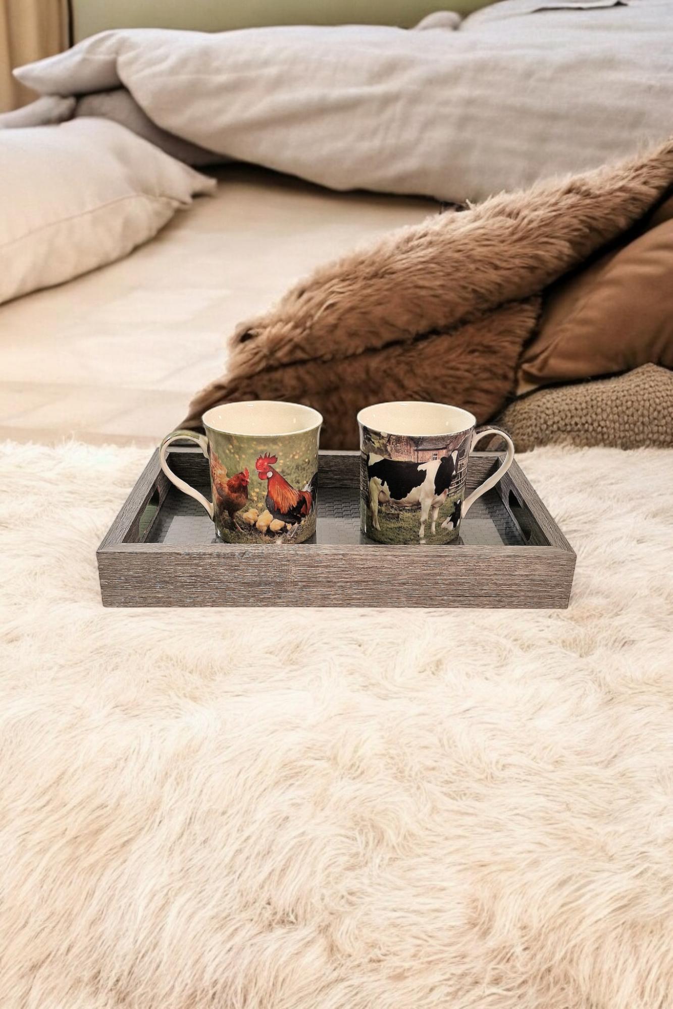Grey weave trays set by Geko Products holding two decorative farm animal mugs on a cozy bed