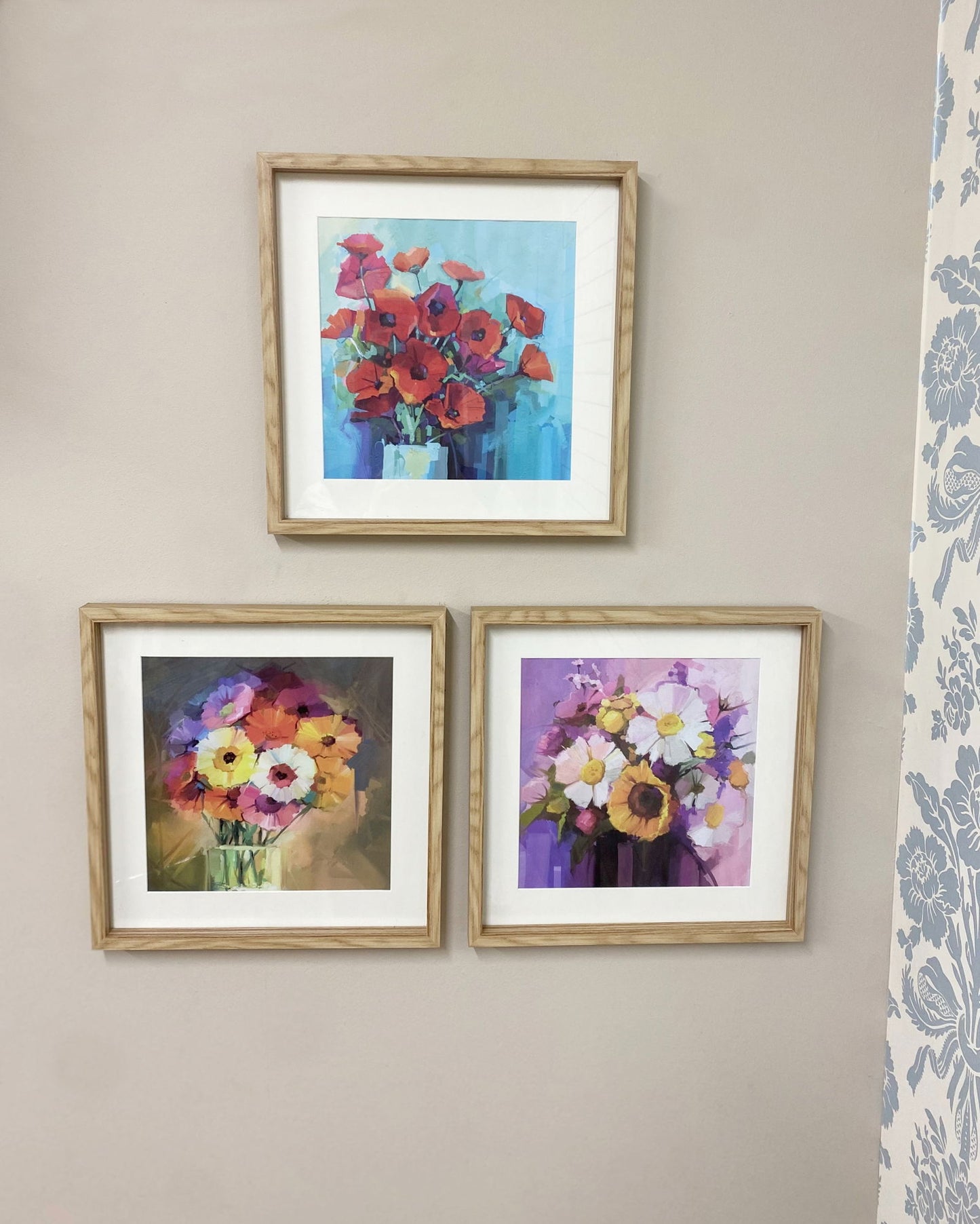 Geko Products sunburst frame set featuring three wooden frames with colorful floral artwork on a beige wall