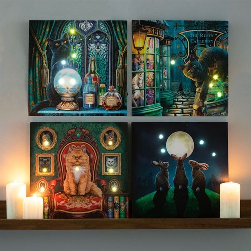 Four illuminated canvases featuring mystical cats and whimsical scenes, showcasing Lisa Parker cat artwork in a cozy setting.