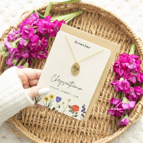 Chrysanthemum birth necklace card for November displayed among pink flowers, showcasing loyalty, honesty, and love.