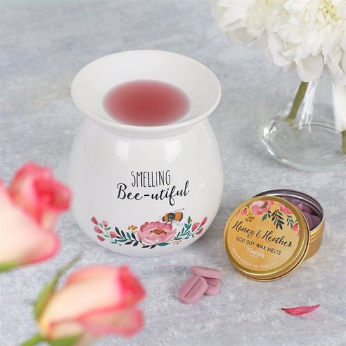 Large Smelling Bee-utiful wax melt warmer with floral design, red wax melt, and nearby blooms for a soothing ambiance.