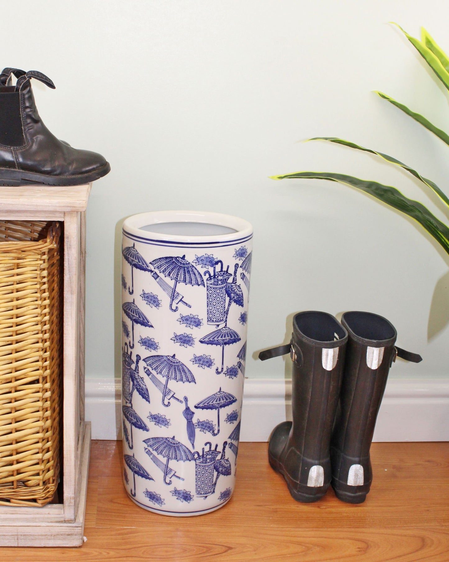 Geko Products vintage umbrella stand with blue umbrella patterns placed beside black boots on wooden floor
