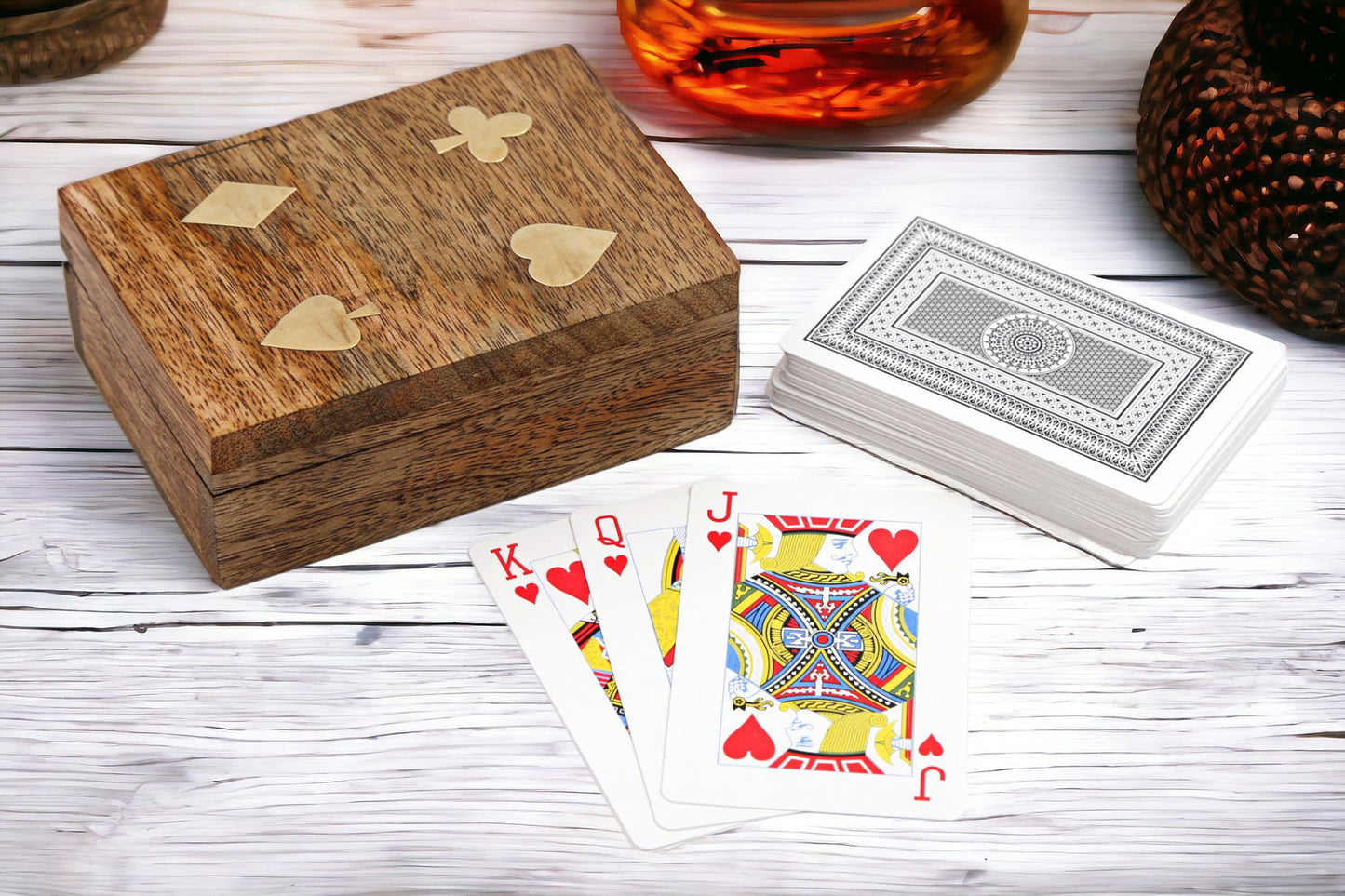 Wooden box playing cards set with natural wood finish and heart suit cards on white wooden table