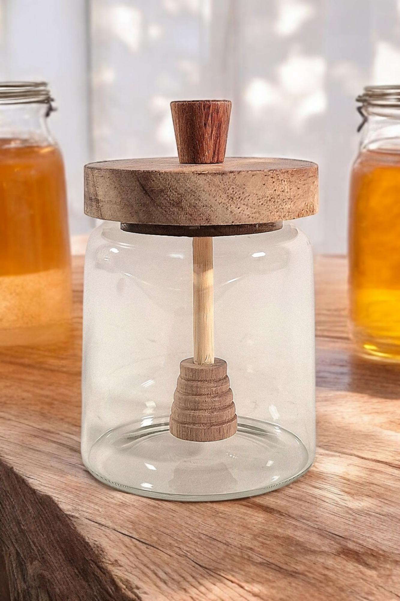 Geko Products glass honey jar with stirrer featuring wooden lid and dipper on rustic wooden table