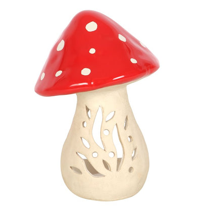 Colorful ceramic mushroom candle holder with a red top and decorative cutouts for tealight candles