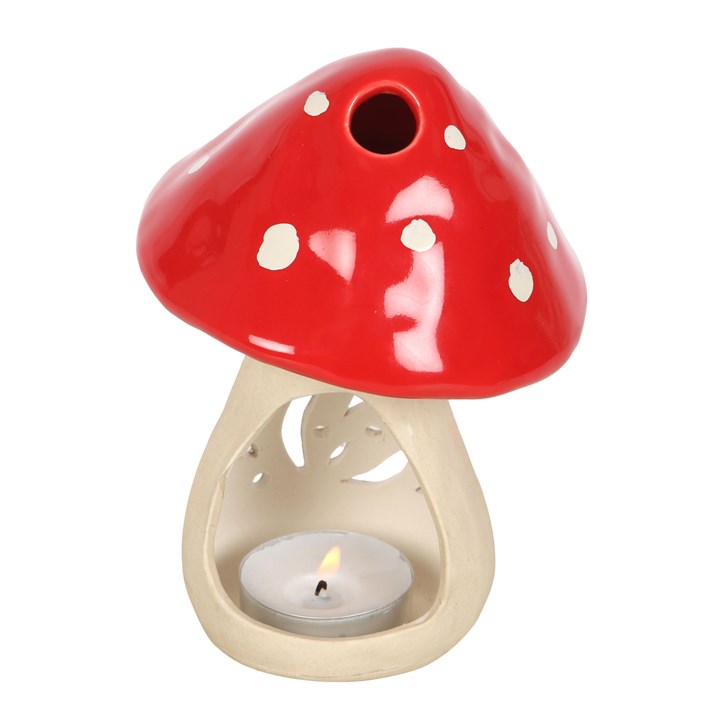 Ceramic mushroom candle holder in red with white spots, featuring a space for a tealight candle underneath
