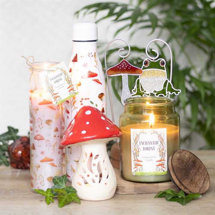 Ceramic mushroom candle holder in a whimsical design surrounded by various candles and decorative items for a cozy atmosphere.