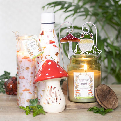 Ceramic mushroom candle holder in a whimsical design surrounded by various candles and decorative items for a cozy atmosphere.