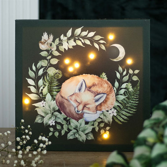 Light up fox canvas art featuring a sleeping fox surrounded by greenery and decorative lights for a cosy ambiance