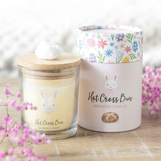 Hot cross bun candle in a glass jar with a wooden lid and decorative packaging, featuring a nostalgic aroma