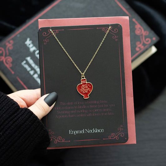 Love potion enamel necklace on a card with inspiring text, displayed elegantly against a dark background