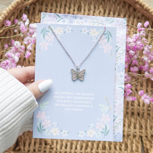 Butterfly Necklace displayed elegantly on a floral greeting card, symbolising strength and transformation, from Kimchi Toki