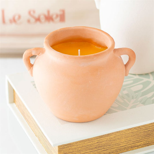 Terracotta urn candle with a bright yellow wax, ideal for home decor, from Kimchi Toki store offering spiritual products