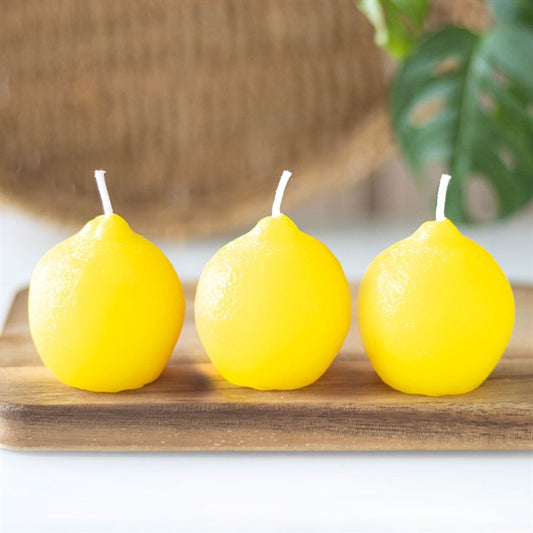 Set of 3 lemon shaped candles set in vibrant yellow, displayed on a wooden tray for a fresh, decorative touch