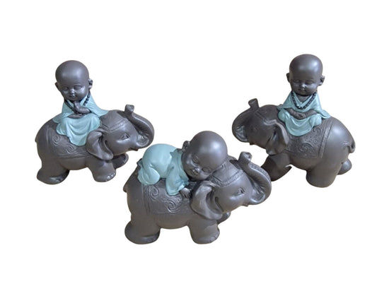 Geko Products Buddha elephant figurines showing three small monks in blue robes sitting on intricately designed elephants