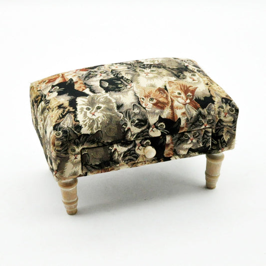 Cat fabric footstool with drawer featuring multiple cat faces printed on fabric and wooden legs