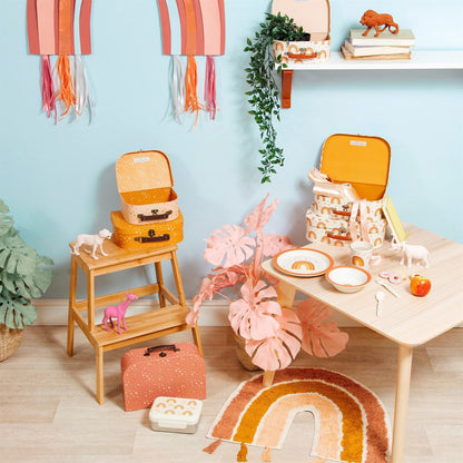 Earth rainbow rug with tassels on floor in colorful kids playroom with toys and decor
