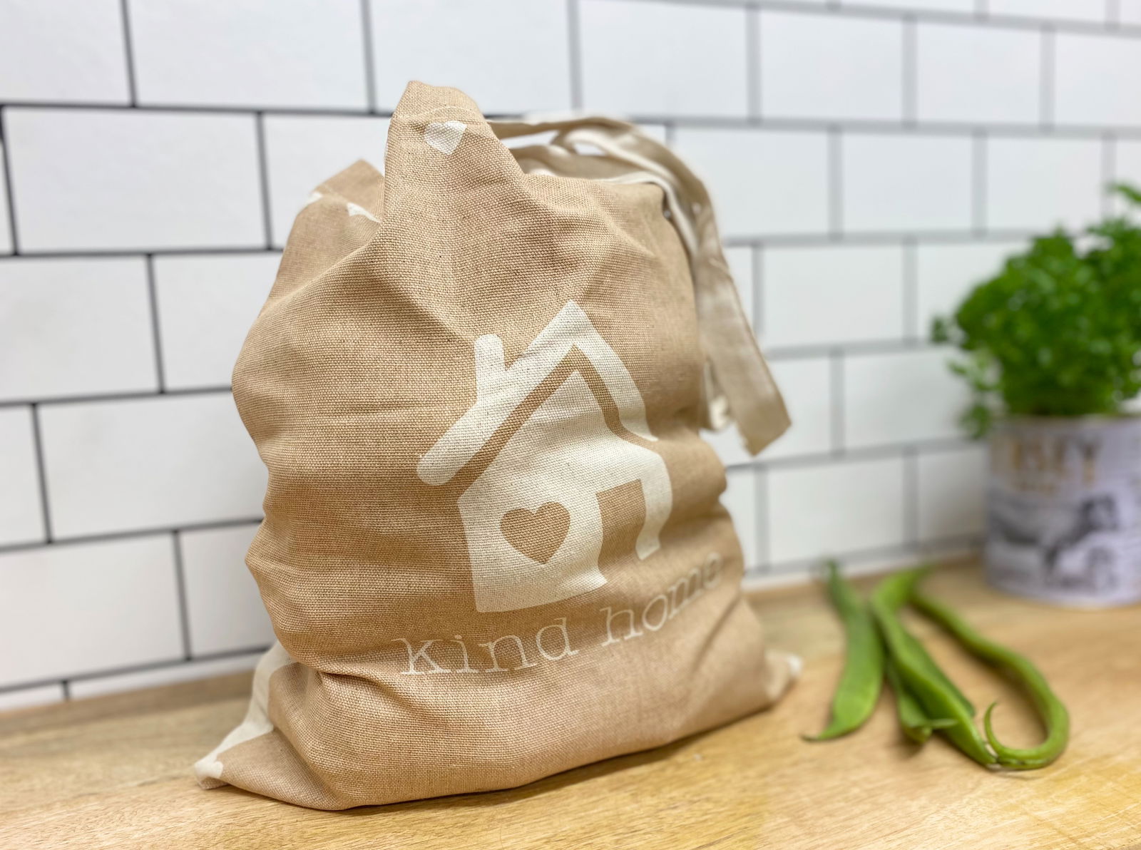 Geko Products eco-friendly tote bag in beige with kind home design on wooden countertop