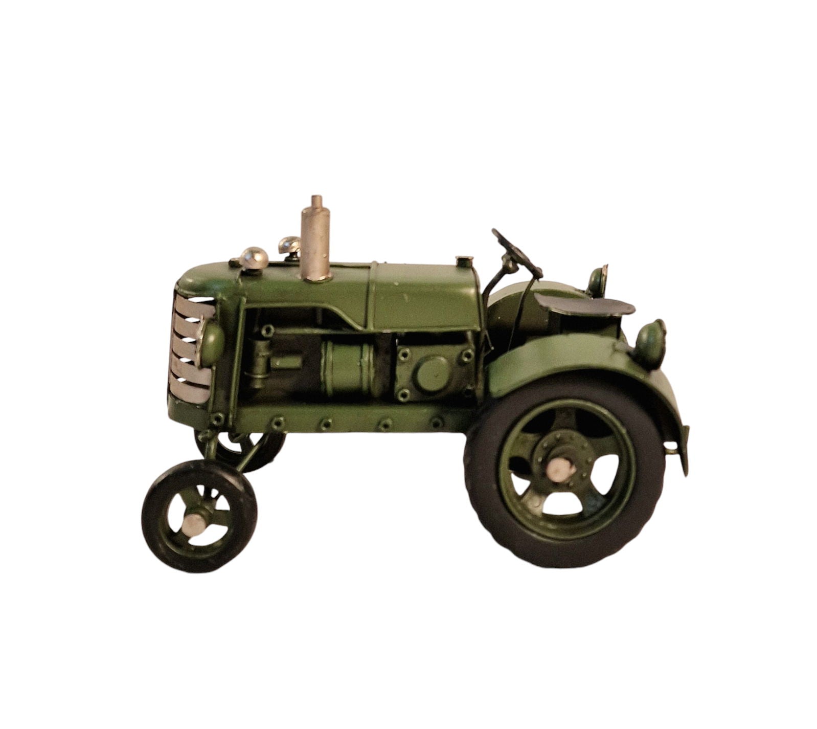 Green metal tractor ornament with detailed vintage design and large rear wheels