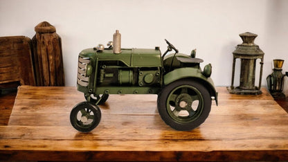 Green metal tractor ornament with detailed design placed on wooden table by Geko Products