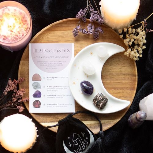 Love Healing Crystal Set displayed on a crescent moon dish with a guide and decorative candles