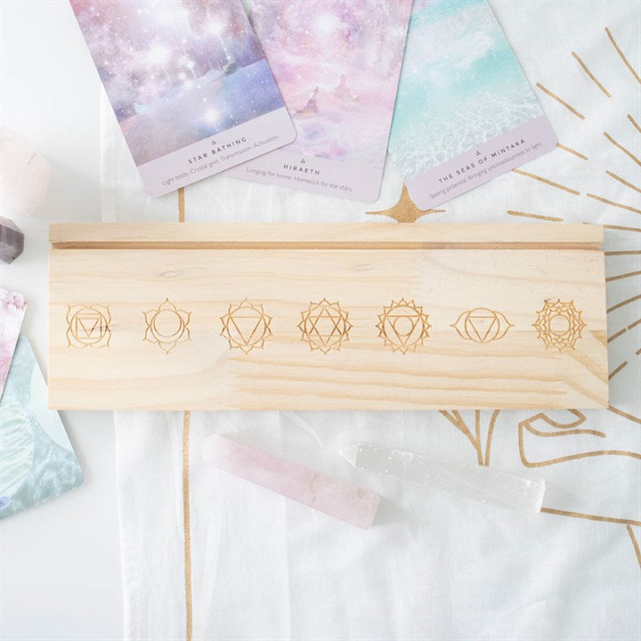 Natural chakra card stand made of light wood with engraved chakra symbols for holding cards
