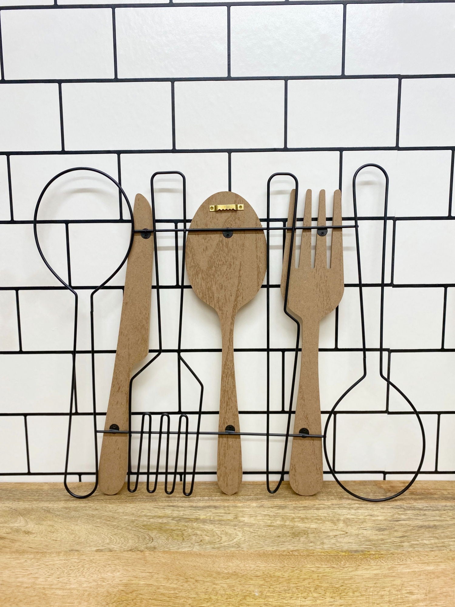 Geko Products unique cutlery wall art featuring wooden and metal spoon, fork, and knife on white tiled background