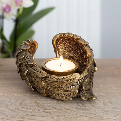 Antique gold angel wing candle holder elegantly cradling a tealight candle, ideal for home decor and spiritual ambiance